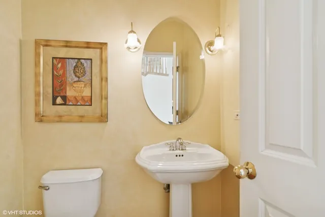 a bathroom with a toilet sink and mirror