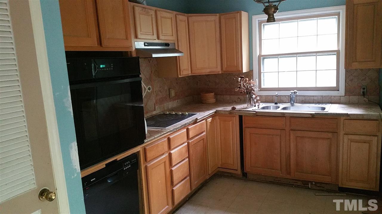 504 Old Farm Road Raleigh, NC 27606 - Photo 2 of 6 a kitchen with granite countertop white cabinets and black appliances