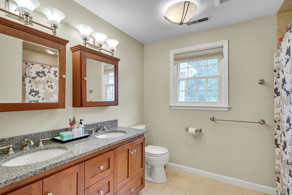 7 Stouffer Circle Andover, MA 01810 - Photo 26 of 37 a bathroom with a granite countertop toilet sink and mirror