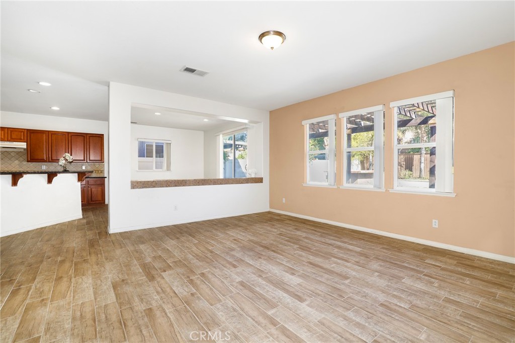 3437 Nature Trail Court Perris, CA 92571 - Photo 11 of 49 an empty room with wooden floor and windows