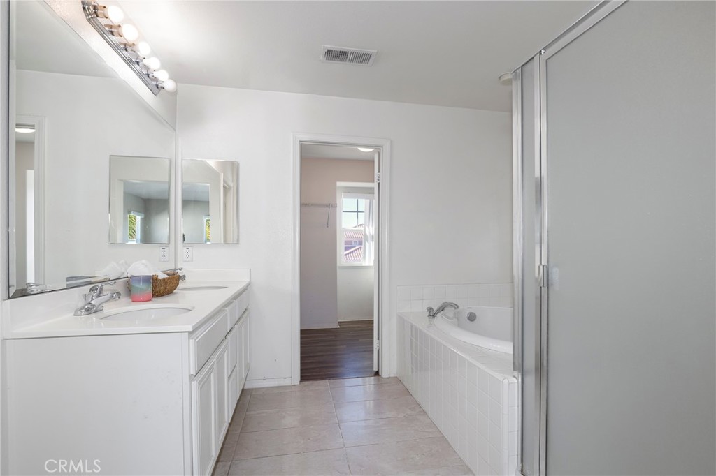 3437 Nature Trail Court Perris, CA 92571 - Photo 38 of 49 a bathroom with a tub a sink and mirror