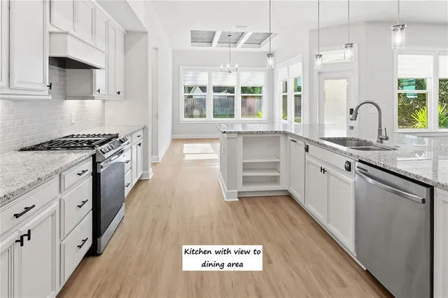 a kitchen with granite countertop a stove and a sink
