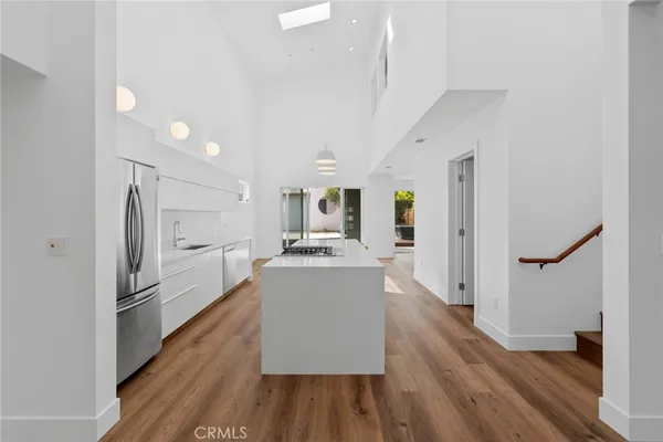 a kitchen with stainless steel appliances a refrigerator stove and wooden floor