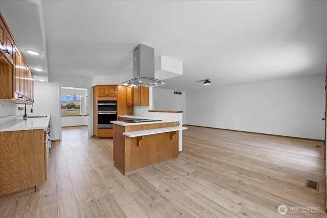 a kitchen with stainless steel appliances wooden floors and wooden cabinets