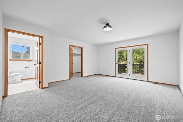 an empty room with windows and bathroom view