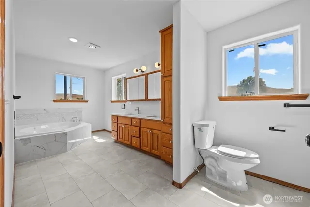 a bathroom with a granite countertop toilet a sink and bathtub