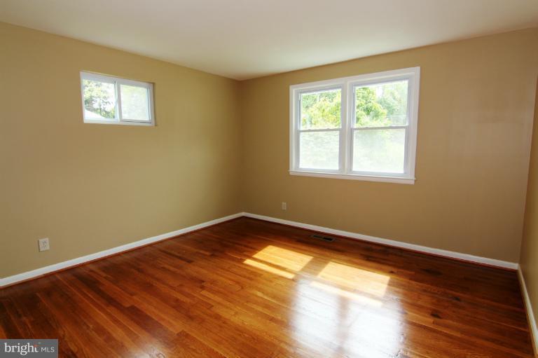 9114 Samoset Road Randallstown, MD 21133 - Photo 1 of 13 a view of an empty room with wooden floor and a window