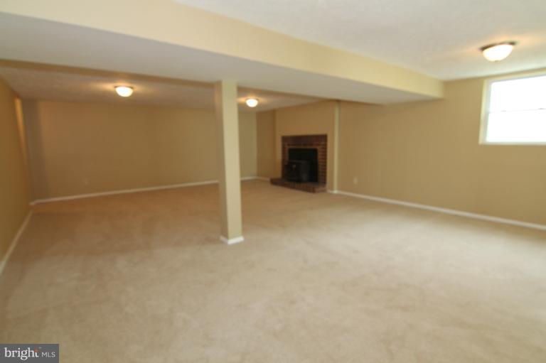 9114 Samoset Road Randallstown, MD 21133 - Photo 2 of 13 an empty room with a fireplace and a window