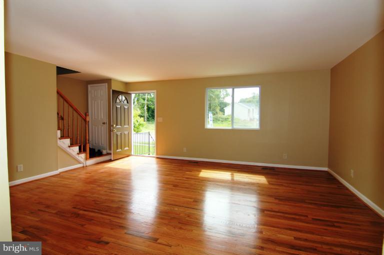9114 Samoset Road Randallstown, MD 21133 - Photo 6 of 13 a view of an empty room with wooden floor and a window