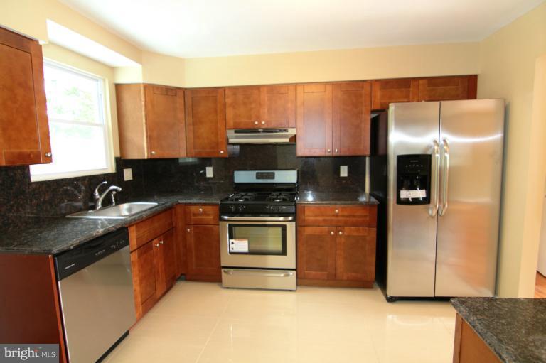 9114 Samoset Road Randallstown, MD 21133 - Photo 8 of 13 a kitchen with stainless steel appliances granite countertop a refrigerator a sink and a stove