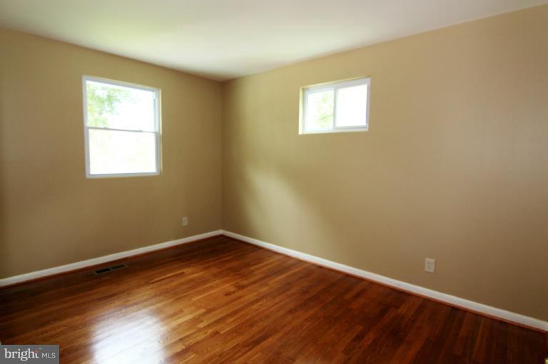 9114 Samoset Road Randallstown, MD 21133 - Photo 10 of 13 wooden floor in an empty room with a window