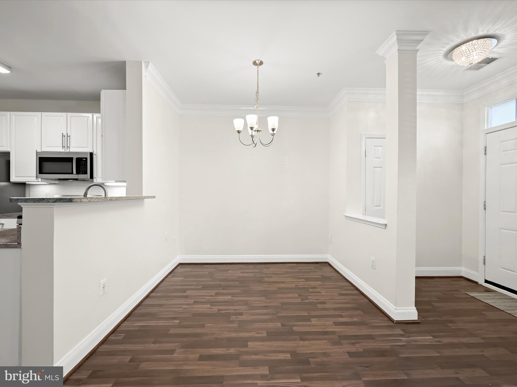 2711 Middle Neck Road Odenton, MD 21113 - Photo 7 of 42 a view of a hallway with wooden floor and a chandelier