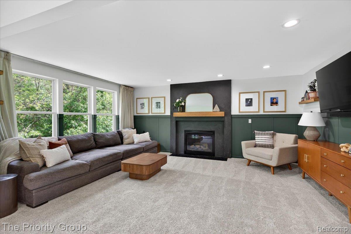 517 Deer Valley Road Holly, MI 48442 - Photo 22 of 61 Living area featuring a large fireplace, carpet, recessed lighting, wainscoting