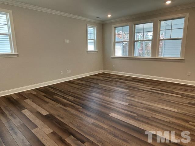 192 Edge Of Auburn Boulevard Raleigh, NC 27610 - Photo 6 of 44 a view of an empty room with wooden floor and a window