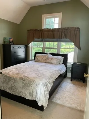a large bed sitting in a bedroom next to a window