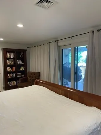 a bed sitting in a spacious bedroom next to a window