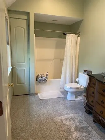a bathroom with a toilet and a shower