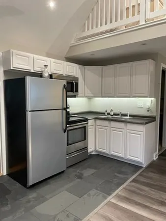 a kitchen with granite countertop a refrigerator and a stove