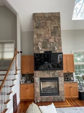 a living room with furniture a flat screen tv and a fireplace