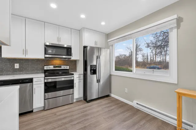 a kitchen with stainless steel appliances a stove a refrigerator and a window