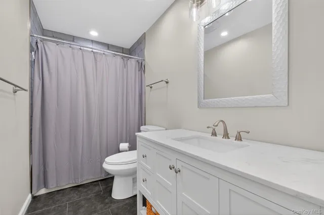 a bathroom with a toilet a sink and a mirror