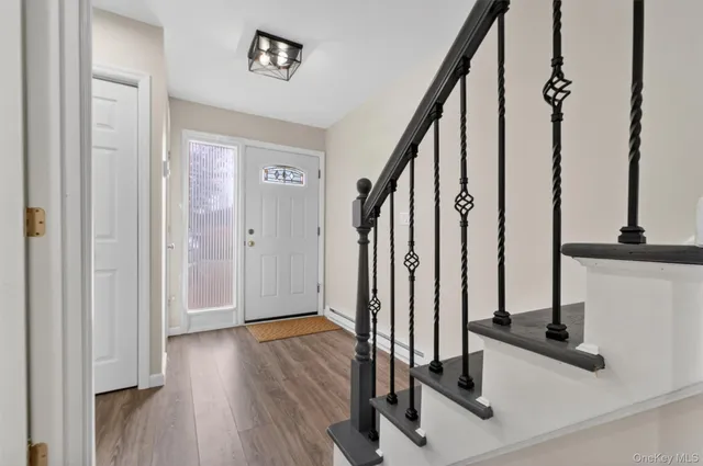 a view of a hallway with wooden floor and staircase