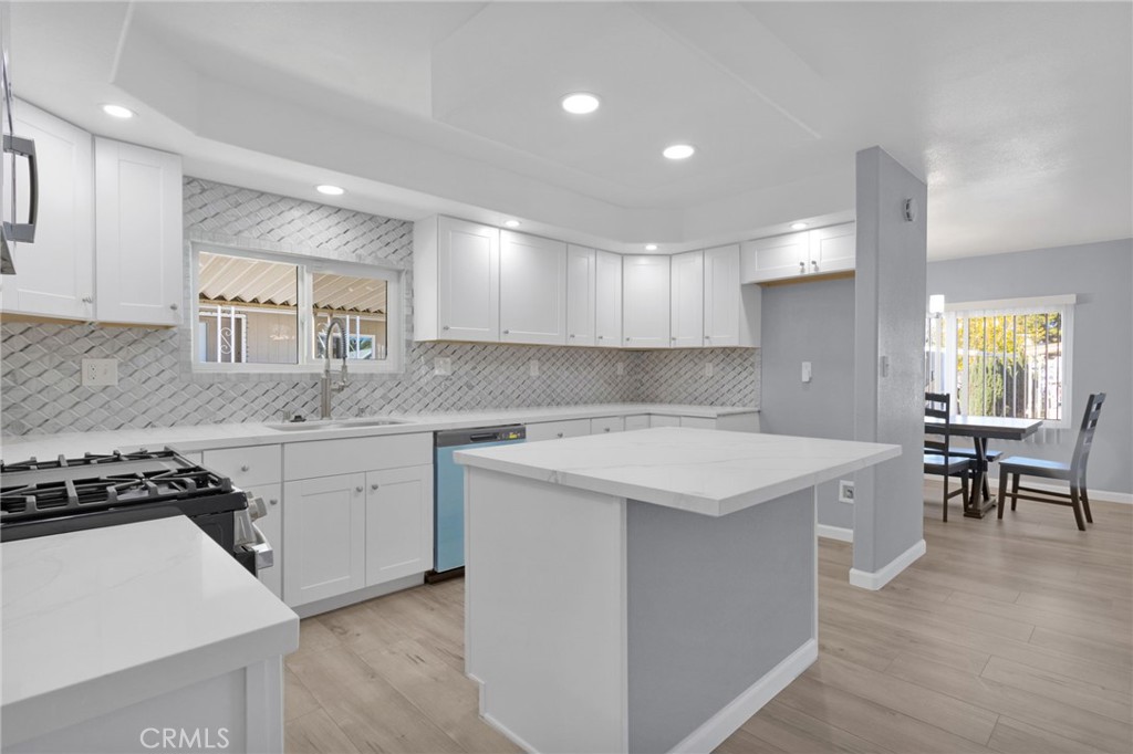 15252 Seneca Road, Unit 221 Victorville, CA 92392 - Photo 7 of 29 a kitchen with a stove a sink a dining table and chairs