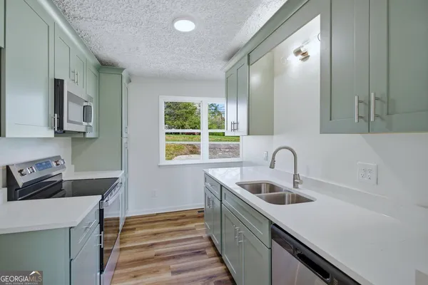 a kitchen with a sink a stove and cabinets