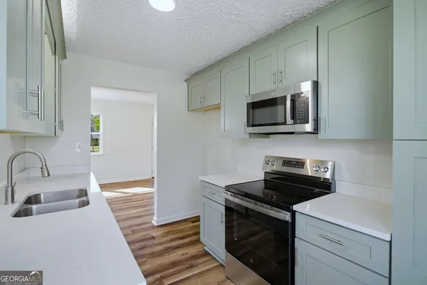 a kitchen with stainless steel appliances a stove microwave and sink