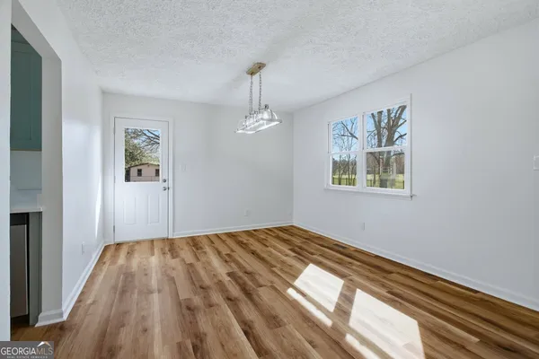 a view of empty room with wooden floor