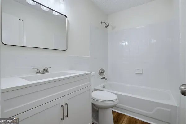 a bathroom with a toilet a sink a mirror and bathtub
