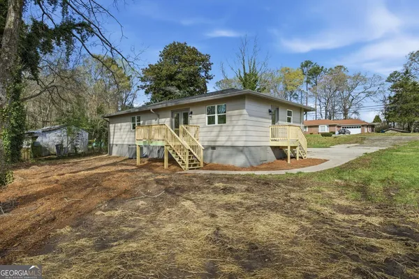 a view of a yard in front of a house with large trees