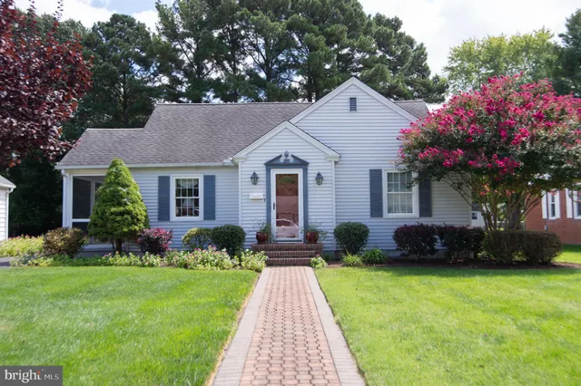 a front view of a house with a garden and plants