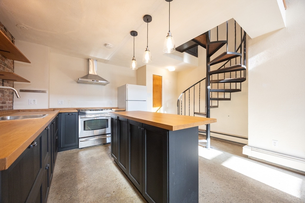 20 Beacon Street, Unit 2 Chelsea, MA 02150 - Photo 12 of 40 a kitchen with stainless steel appliances granite countertop a sink a stove and a refrigerator