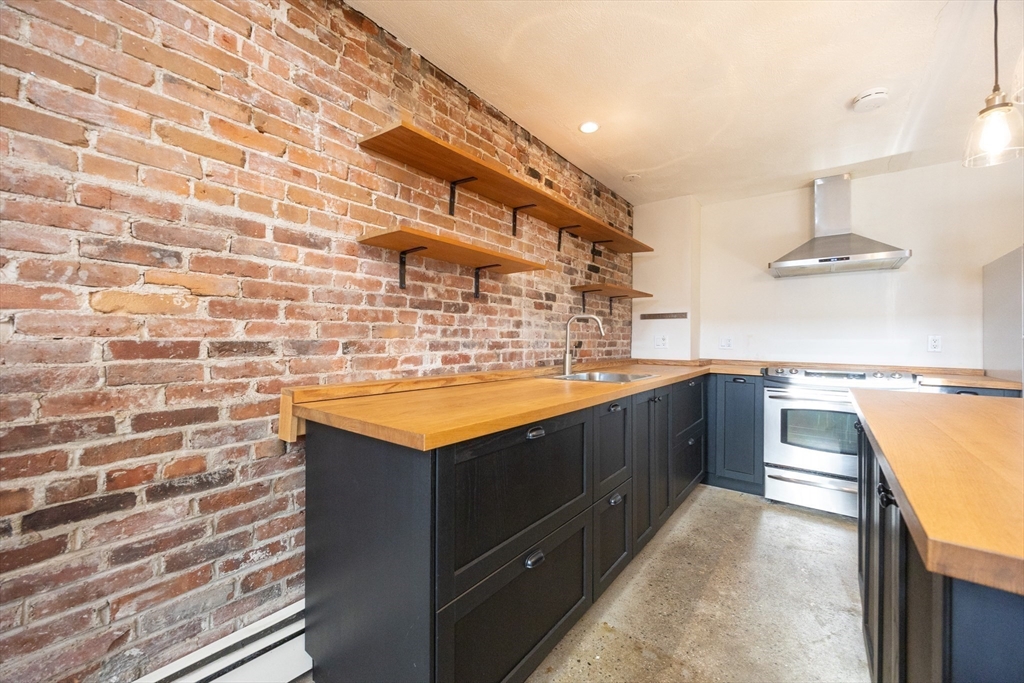 20 Beacon Street, Unit 2 Chelsea, MA 02150 - Photo 13 of 40 a kitchen with stainless steel appliances granite countertop a sink and a stove