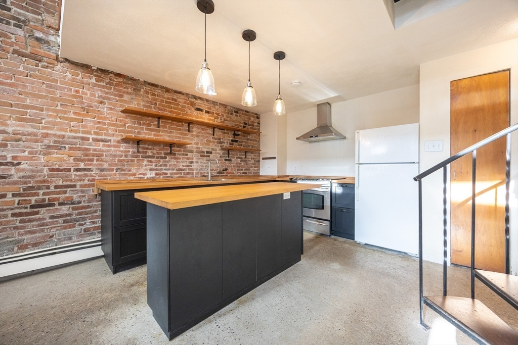 20 Beacon Street, Unit 2 Chelsea, MA 02150 - Photo 14 of 40 a kitchen with stainless steel appliances granite countertop a sink a stove and a refrigerator