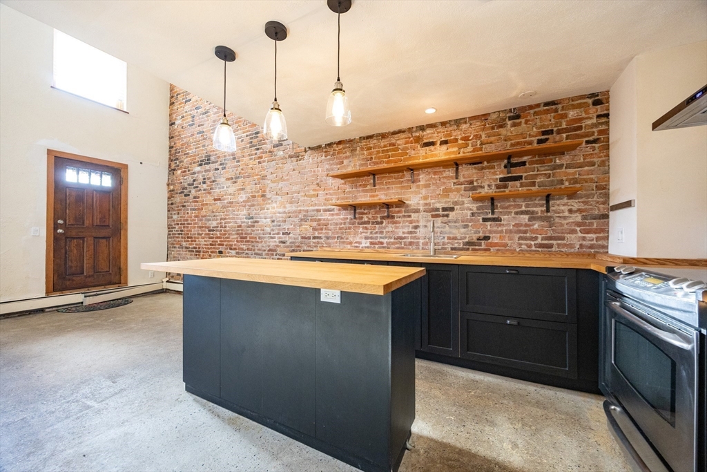 20 Beacon Street, Unit 2 Chelsea, MA 02150 - Photo 21 of 40 a kitchen with stainless steel appliances granite countertop a sink a stove and a wooden floors