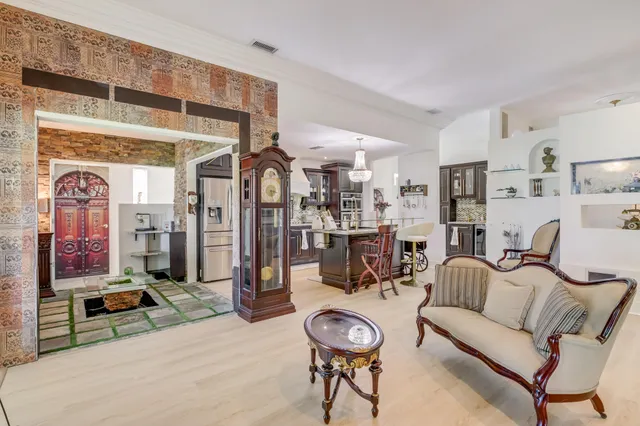 a living room with furniture a rug and kitchen view