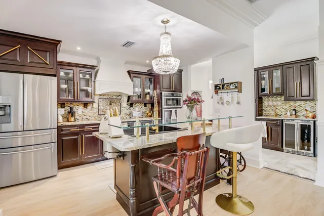 a kitchen with stainless steel appliances granite countertop a stove oven and a refrigerator with white cabinets