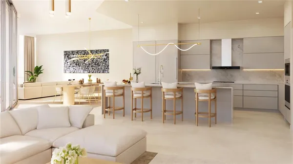 a living room with furniture a kitchen island with white cabinets and stainless steel appliances