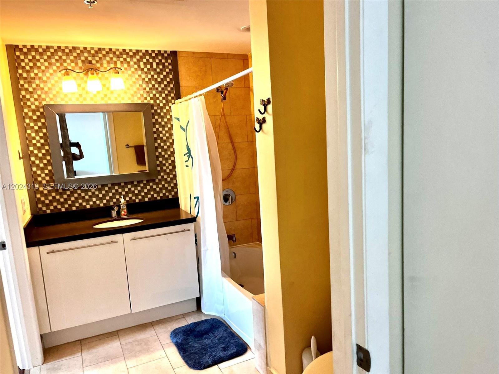 90 Southwest 3rd Street, Unit 1409 Miami, FL 33130 - Photo 15 of 25 a bathroom with a sink and a mirror