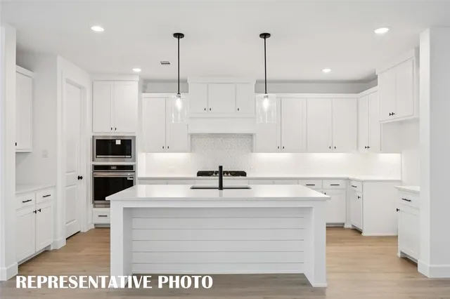 a kitchen with kitchen island white cabinets and stainless steel appliances
