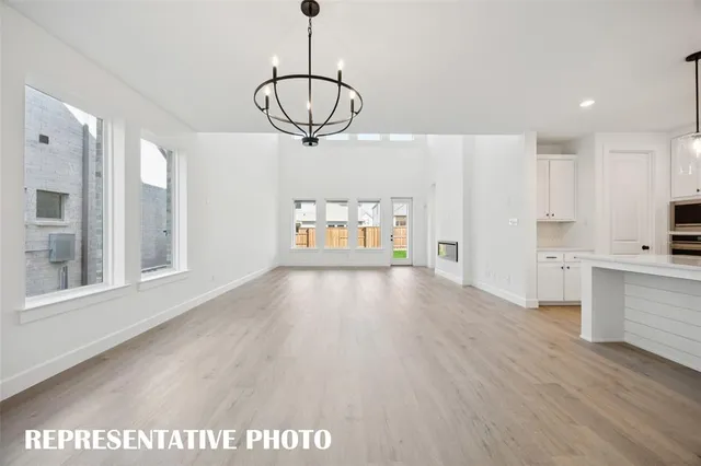 a view of empty room with wooden floor and window