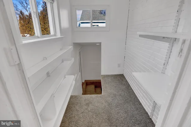 a bedroom with a bed wall painting and a window