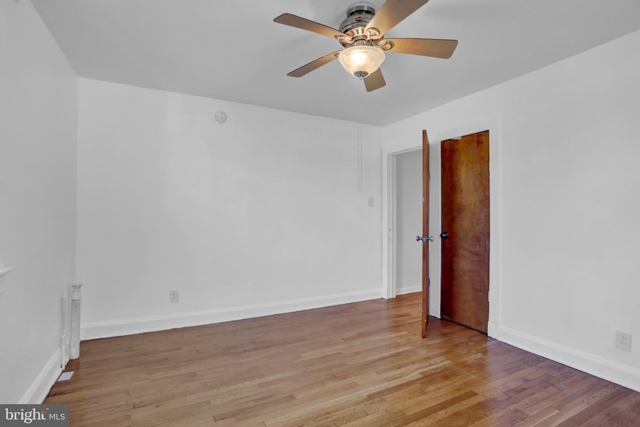 9036 Simms Court Parkville, MD 21234 - Photo 21 of 52 an empty room with wooden floor and ceiling fan