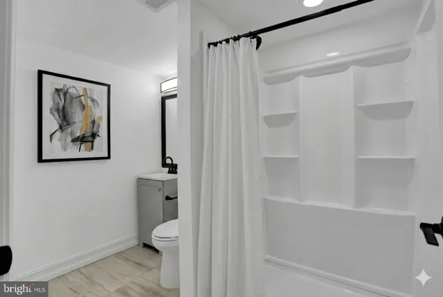 a bathroom with a shower a toilet and a sink