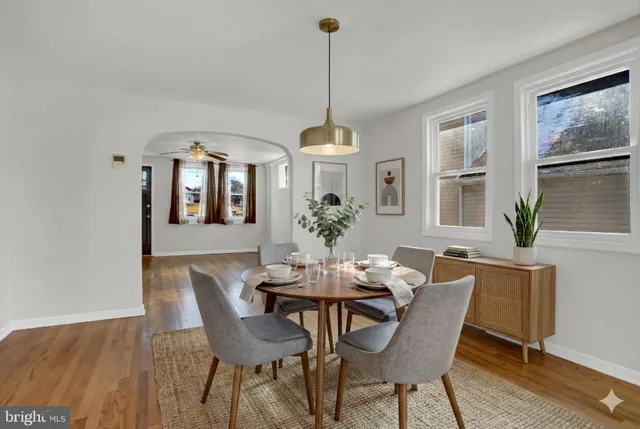a dining room with furniture a chandelier and wooden floor