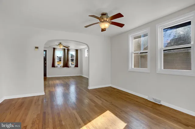 a view of a livingroom with wooden floor and a ceiling fan