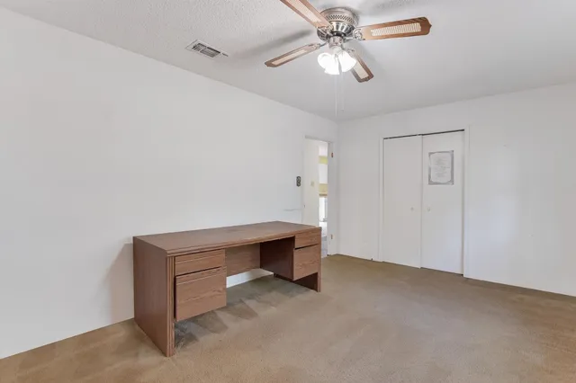 a room with a table and ceiling fan