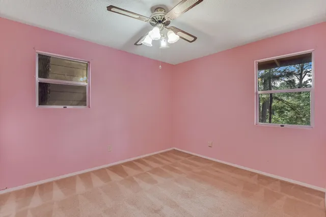 a view of a big room with window and ceiling fan